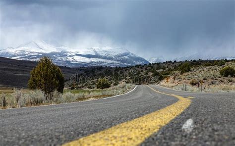 Low Angle Empty Asphalt Road Leading Towards The Breathtaking Snowy