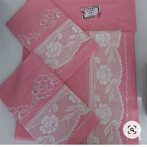 Three Pink Napkins With White Lace On Them And A Bottle Of Perfume Next