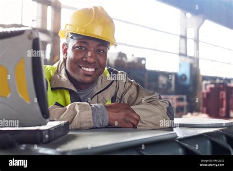 Portrait Smilingconfident Steelworker At Laptop In Steel Mill Stock