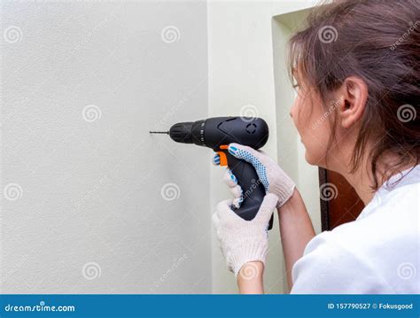 Woman Using A Drill Drills A Hole In The Wall Stock Image Image Of