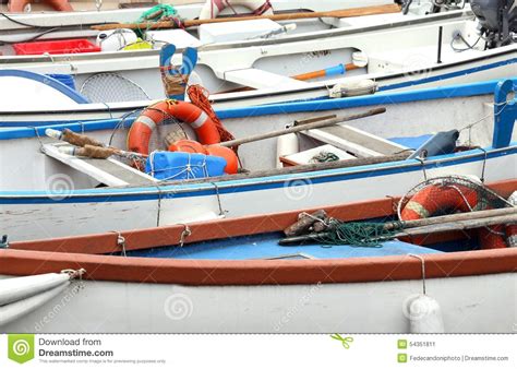 Los Barcos De Rowing Y Los Barcos De Motor Amarraron En El Embarcadero