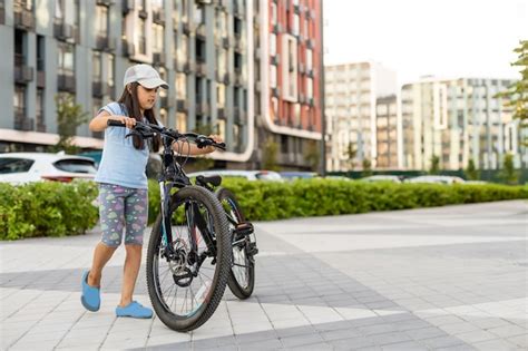 Niña feliz montando en bicicleta en la ciudad Foto Premium