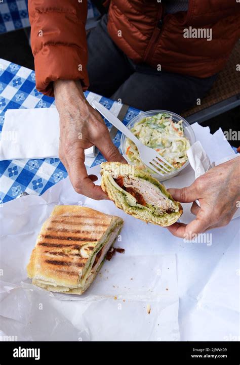 A Customer Enjoys A Sandwich At The Landmark Italian American Deli