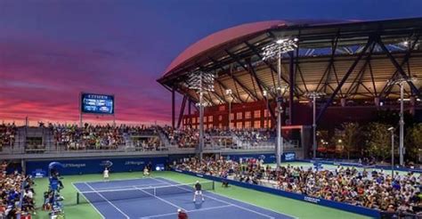 A Tennis Match Is Being Played In Front Of An Arena Full Of Spectators