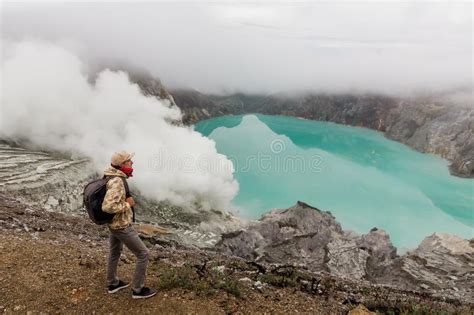 O Turista Do Homem Olha O Lago Do Enxofre No Vulc O De Ijen Na Ilha