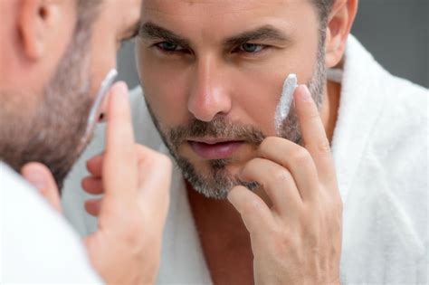 Premium Photo Beauty Man Applying Face Cream Skincare Cream Skin