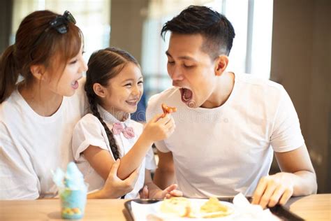 Familia Feliz Que Disfruta De La Cena En Restaurante Imagen De Archivo