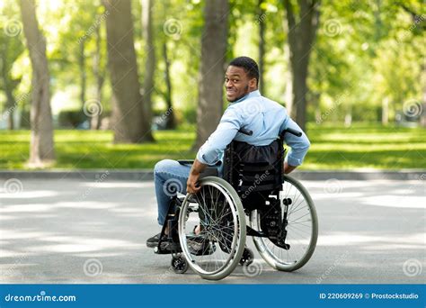 Joyful Handicapped Black Man In Wheelchair Spending Time At City Park