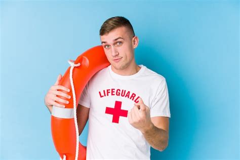 Premium Photo Young Lifeguard Man Holding A Rescue Float Pointing