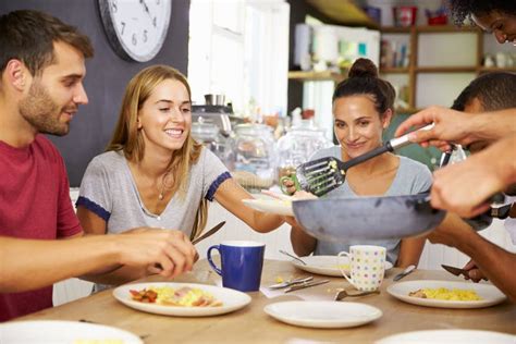 Groupe Damis Appréciant Le Petit Déjeuner Dans La Cuisine Ensemble