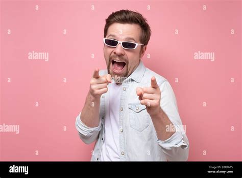 Happy Mature Man Pointing At You Against Pink Background Studio Shot