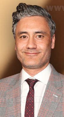 a man with grey hair wearing a suit and tie