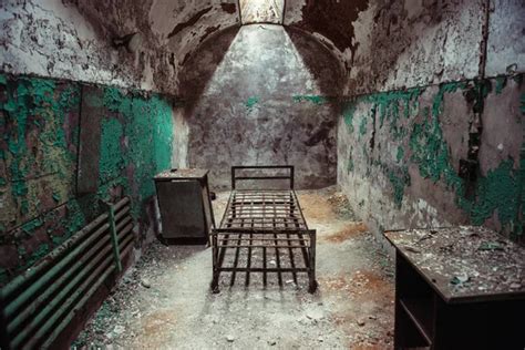 Abandoned prison cell walkway with old rusty stairs, doors and peeling ...