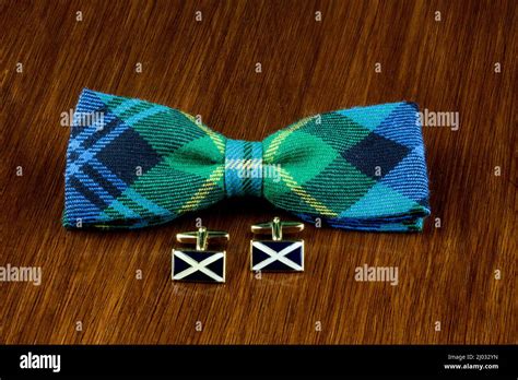 Scottish Saltire Cuff Links With Tartan Bow Tie On A Polished Wooden