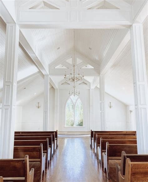 An Empty Church With Wooden Pews And Chandelier Hanging From The