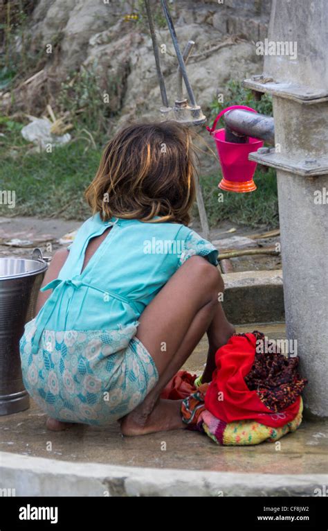 A Young Girl Washing Clothes At The Village Hand Pump Allahabad India