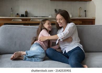 Happy Playful Mom Tickling Excited Daughter Stock Photo