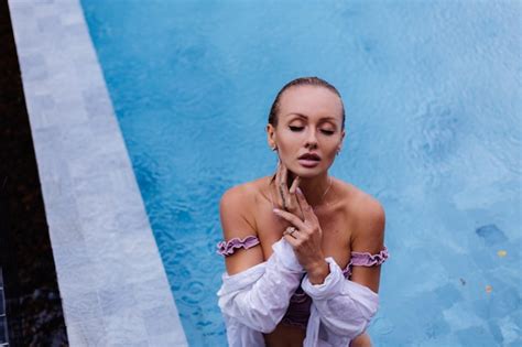 Portrait De La Belle Femme Caucasienne En Bikini Et Chemise Blanche Dans La Piscine Bleue Sous