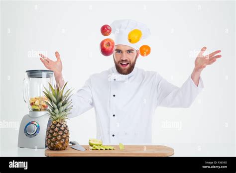 Portrait Of A Hapy Male Chef Cook Juggle With Fruits Isolated On A