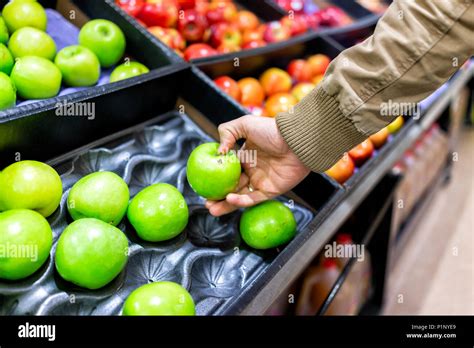 Green Assorted Apples On Display Shelf In Grocery Store Boxes In Aisle