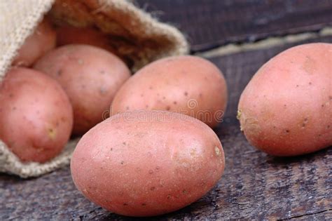 Patatas Rojas En Un Saco Del Yute En La Tabla Foto De Archivo Imagen