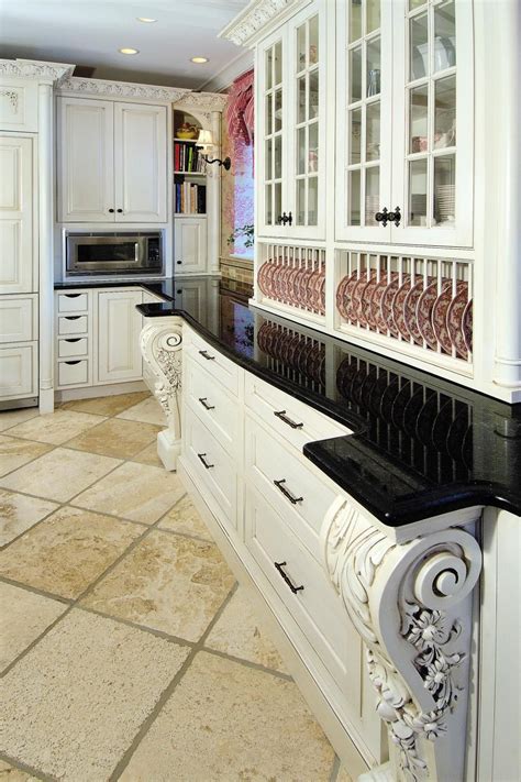 A Large Kitchen With White Cabinets And Black Counter Tops Along With