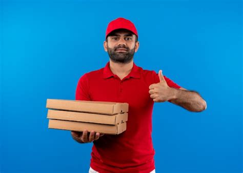 Free Photo Bearded Delivery Man In Red Uniform And Cap Holding Stack