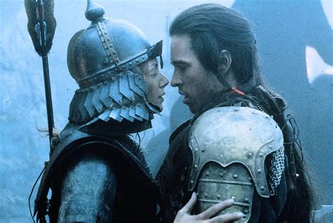 A Man And Woman In Armor Standing Next To Each Other With Helmets On