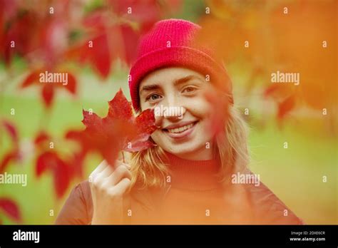 Smiling Teenage Girl Holding Maple Leaf While Standing Outdoors Stock