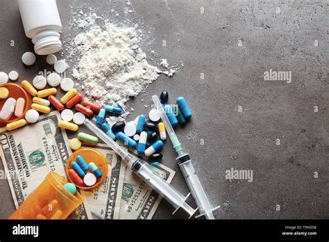 Drugs with money on grey background. Concept of addiction Stock Photo - Alamy