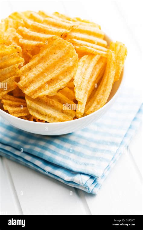 Crinkle Cut Potato Chips On Kitchen Table Tasty Spicy Potato Chips In