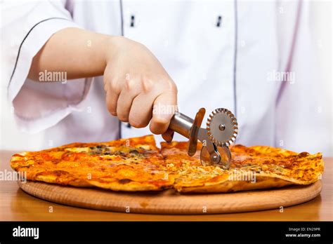 Chef With Knife Cuts The Pizza Closeup Stock Photo Alamy