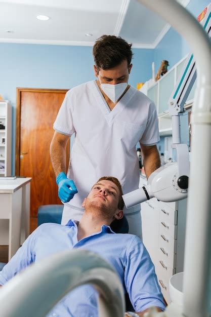 Premium Photo | Male dentist takes jaw x-ray of patient.