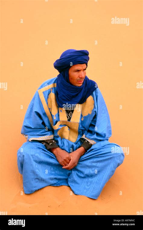 Berber Male In Traditional Costume Resting In The Sands Of The Sahara