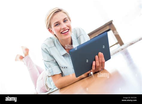 Pretty Blonde Woman Lying On The Floor And Using Her Tablet Stock Photo Alamy