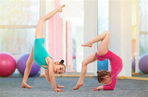 Flexible kids gymnasts doing acrobatic exercise in gym. Sport concept ...