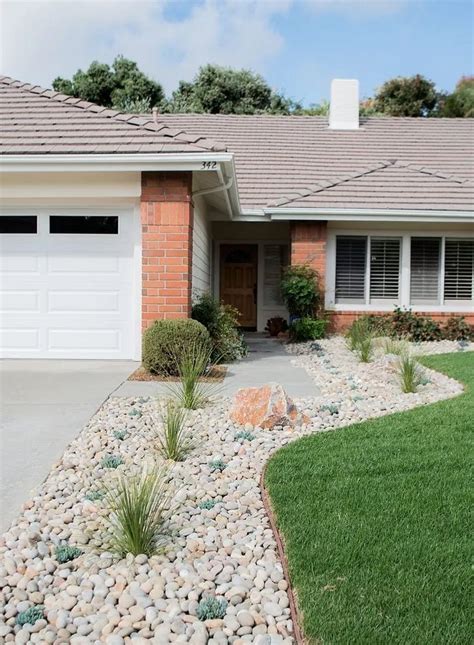 A House With Rocks And Grass In Front Of It