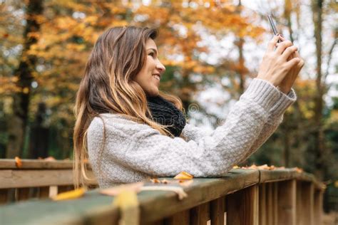 Beautiful Young Happy Woman Taking Selfie With Smartphone In Autumn