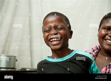 Une Femme Africaine Assis Dans Sa Cuisine Avec Son Fils Smiling At