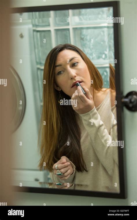 Woman Applying Lipstick In Mirror Stock Photo Alamy