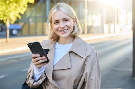 Free Photo Portrait Of Smiling Blonde Woman Wearing Trench Coat On