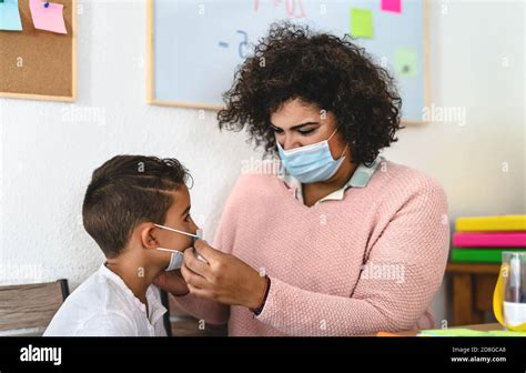 La femme enseignante a mis un masque de protection du visage à l élève