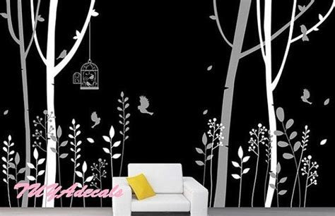 a living room with black and white wallpaper, tree branches and birdcage