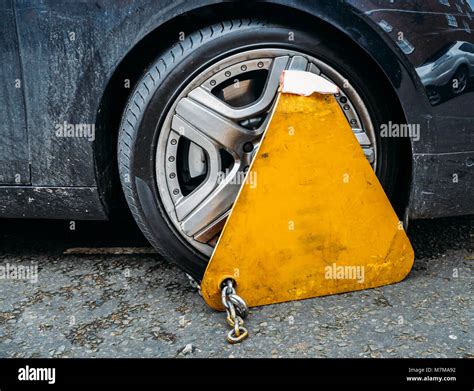 Yellow Triangle Wheel Clamp Locked With Messing Lock And Chain On An