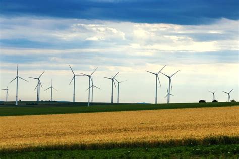 Premium Photo Wind Turbines On Field Against Sky