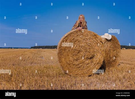 Une Jeune Fille Blonde Aux Cheveux Longs Dans Un Chapeau Blanc Se Repose Et Pose Pr S Des Gerbes