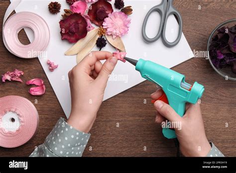 Woman Using Hot Glue Gun To Make Craft At Wooden Table Top View Stock Photo Alamy