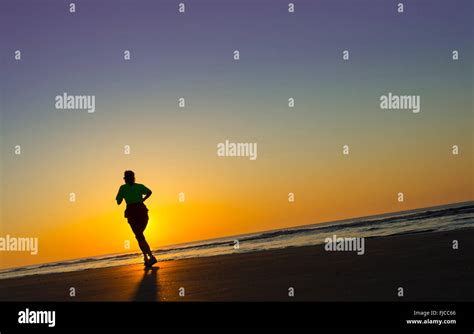 Sunrise Jogger On Beach Stock Photo - Alamy