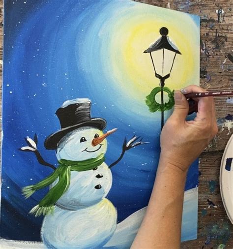 A Person Is Painting A Snowman With A Lamp Post In The Night Time Sky