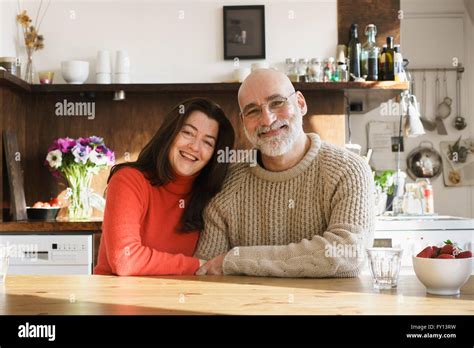 Portrait Of Mature Couple Sitting By Table At Home Stock Photo Alamy